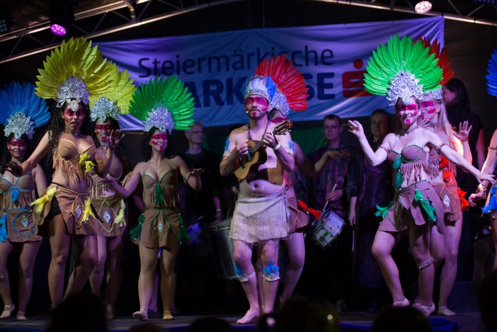 Escola de Samba Baturim Gruppenbild in Kostüm mit Feder-Kopfschmuck, Cavaco-Spieler in der Mitte